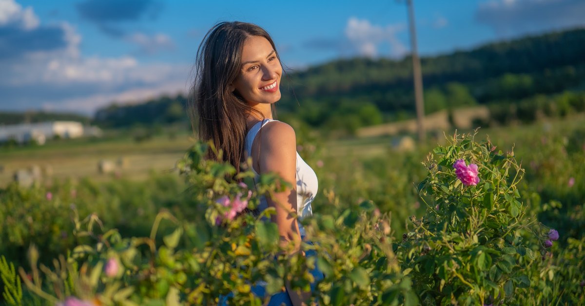 Sieviete ziedošā rožu laukā Bulgārijas Rožu ielejā